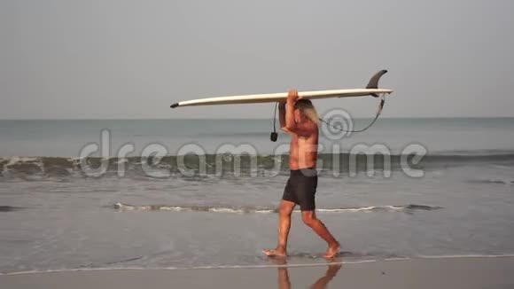 带着冲浪板在海滩上的祖父一个成熟男人的冲浪肖像视频的预览图