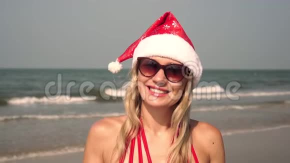 一个女人戴着圣诞帽在海洋背景上的肖像视频的预览图