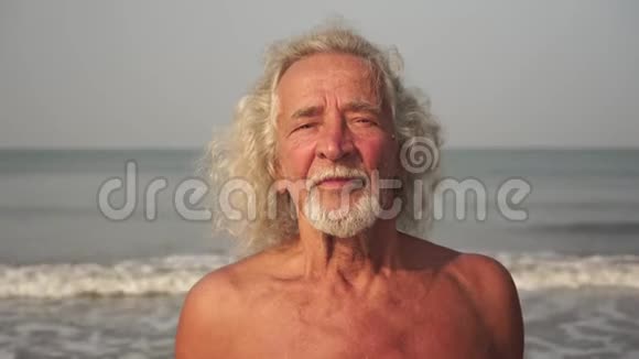 海背景上一位老人的肖像成熟的男人和海滩上的祖父视频的预览图