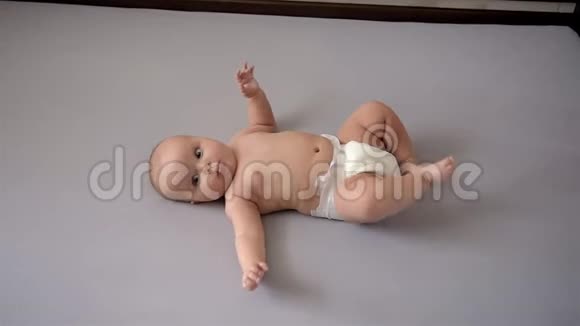 可爱的婴儿躺在他的背上移动他的手臂和腿视频的预览图