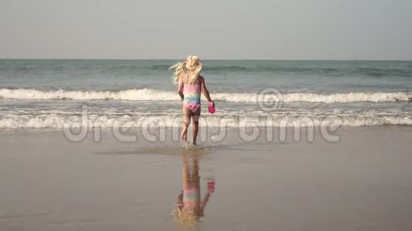 小女孩在海边玩耍溅在水里童年大海旅行视频的预览图