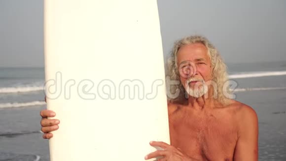 一个有冲浪板的成熟老人的肖像在职老年视频的预览图
