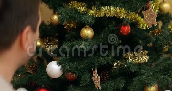 一个人把圣诞玩具从树上移走视频的预览图