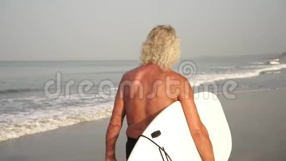 成熟的雄性冲浪者带冲浪板的爷爷视频的预览图
