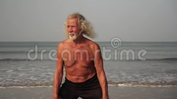 一个成熟的老人正在海滩上训练和运动视频的预览图