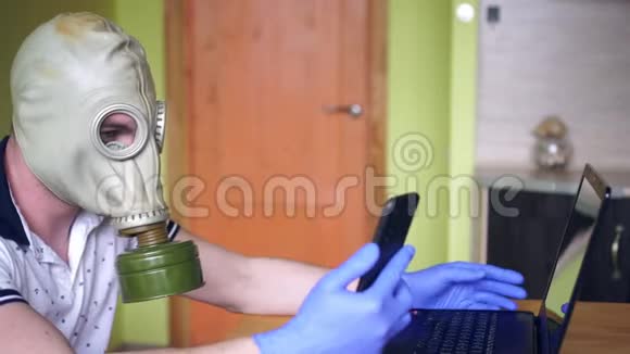 一个带手提电脑和智能手机的人在家里戴着呼吸器内政部和冠状病毒视频的预览图