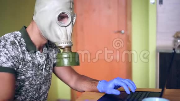 戴防毒面具和带手提电脑的医疗手套的人病毒防护概念视频的预览图