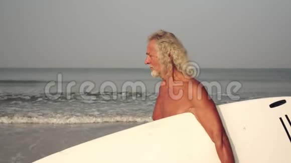 成熟的白发男人正在冲浪有冲浪板的老头在职体育退休人员视频的预览图