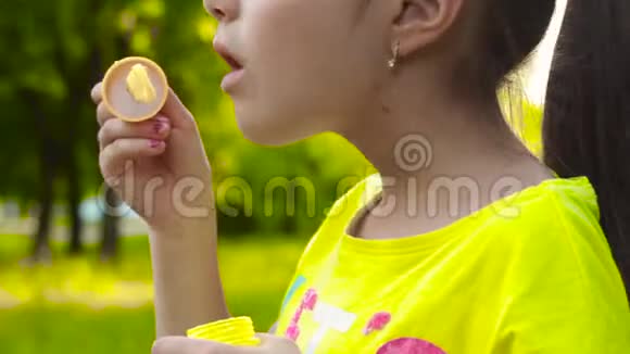 小女孩在公园里吹肥皂泡特写录像视频的预览图