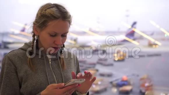 机场的女人带着智能手机机场候机楼的游客使用电话视频的预览图