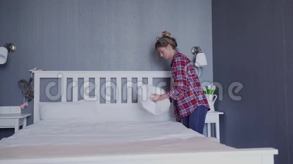 年轻女子在卧室里铺床视频的预览图