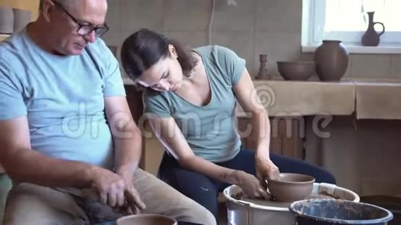 成年陶工在大师班教年轻女子视频的预览图
