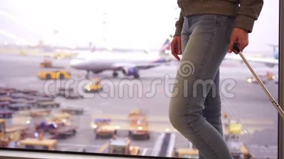 一个女人正拿着一个手提箱在机场候机楼散步视频的预览图