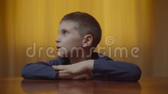 自闭症男孩坐在办公桌前表现情绪的肖像有自闭症的孩子在家里笑得开心视频的预览图