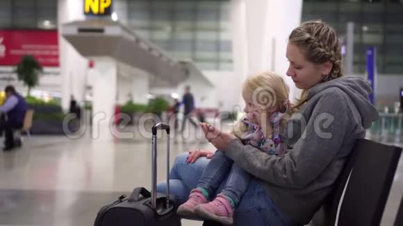 妈妈和女儿在机场休息室在机场有孩子的女人视频的预览图