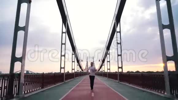 他在城里的一座脚桥上跑步视频的预览图