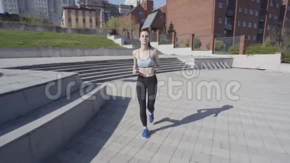 年轻的女人在城市里奔跑视频的预览图