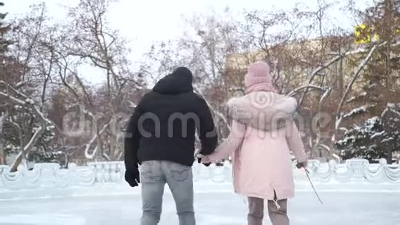 年轻夫妇在溜冰场握着冰鞋视频的预览图