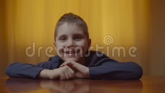 自闭症男孩坐在办公桌前表现情绪的肖像有自闭症的孩子在家里笑得开心视频的预览图