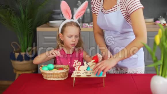 装饰复活节餐桌的女人和小女孩视频的预览图