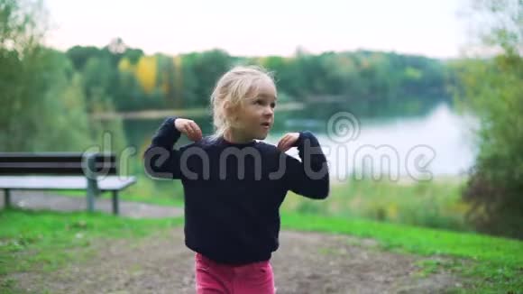 可爱的小女孩在城市公园做运动视频的预览图