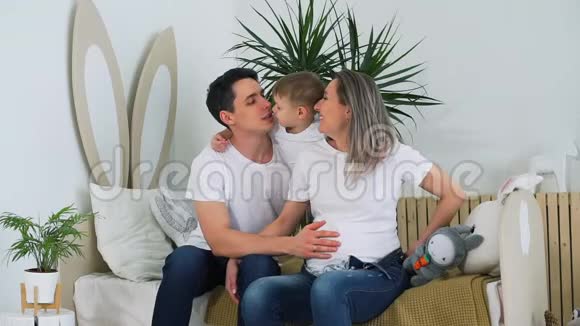 小男孩拥抱他的父亲和怀孕的母亲视频的预览图