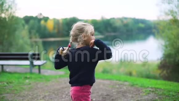 可爱的小女孩在公园里做体操视频的预览图