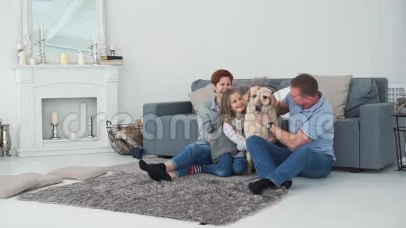 一家人带着狗坐在沙发附近视频的预览图