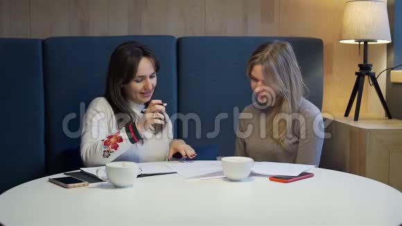 年轻女子在咖啡店签署文件视频的预览图