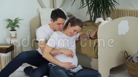 年轻男子抚摸怀孕妻子的腹部视频的预览图