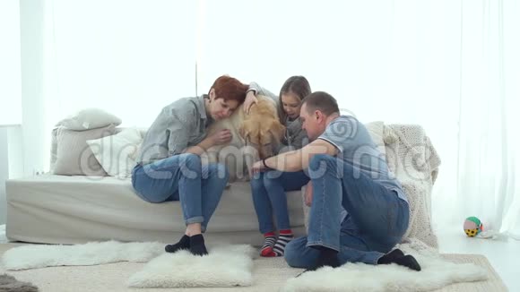 狗和女儿坐沙发的父母视频的预览图