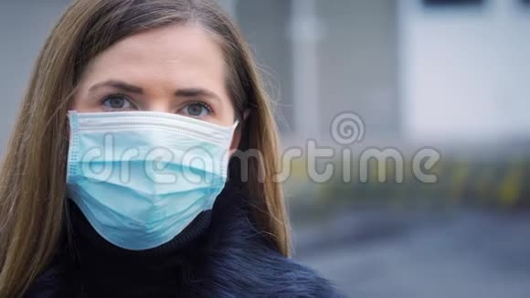 年轻女性佩戴蓝色一次性病毒脸口鼻罩特写人像背景模糊冠状病毒covid19视频的预览图