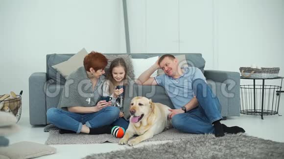 在沙发附近放松狗的快乐家庭视频的预览图