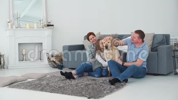 有女儿和狗的父母在沙发附近放松视频的预览图