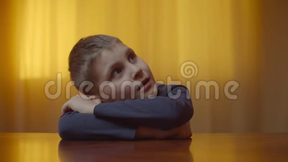 自闭症男孩坐在办公桌前表现情绪的肖像患有自闭症的孩子闭着眼睛是因为视频的预览图