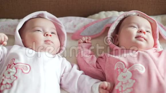 两个可爱的双胞胎姐妹躺在毯子上视频的预览图