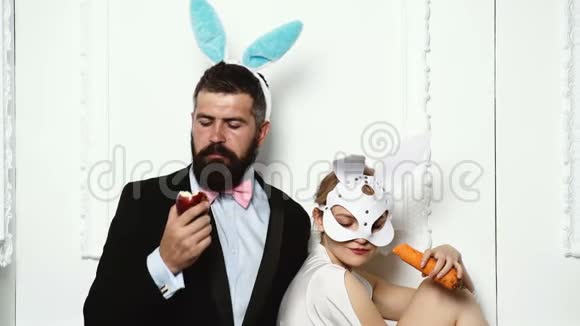 穿着胡萝卜和苹果的兔子装白色背景上的兔子夫妇匹诺普女古董看视频的预览图