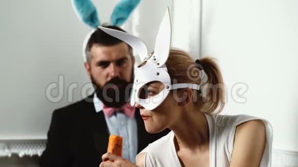 热复活节夫妇有兔子耳朵把一个戴皮兔面具吃胡萝卜的女孩关起来视频的预览图