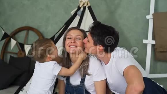 父亲和儿子在托儿所亲吻怀孕的母亲视频的预览图