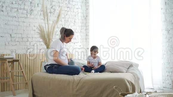 怀孕母亲玩纸牌游戏小儿子视频的预览图