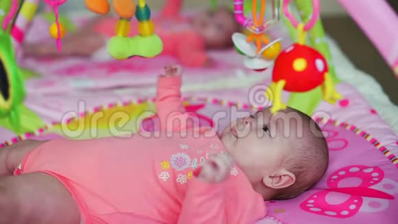 可爱的双胞胎宝宝在五颜六色的垫子上视频的预览图