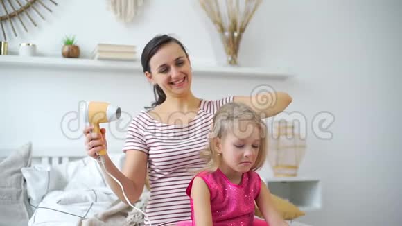 年轻女子在家给女儿晒头发视频的预览图
