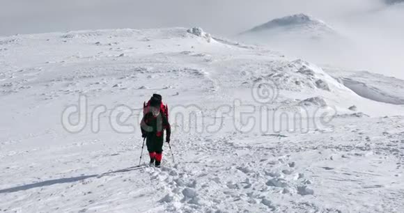 在阳光明媚的日子里在冬天的山上徒步旅行者视频的预览图