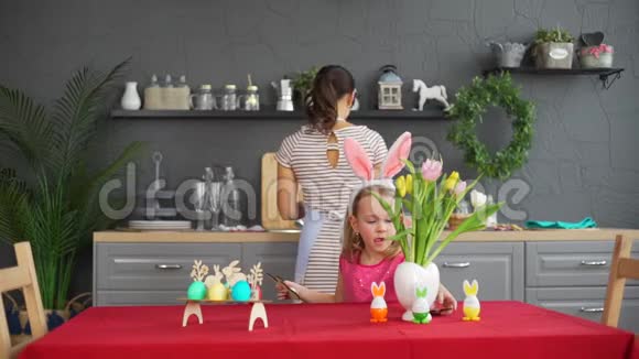 可爱的小女孩在家装饰复活节餐桌视频的预览图