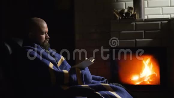 有胡子的人在壁炉旁看书秃头模特在家放松视频的预览图