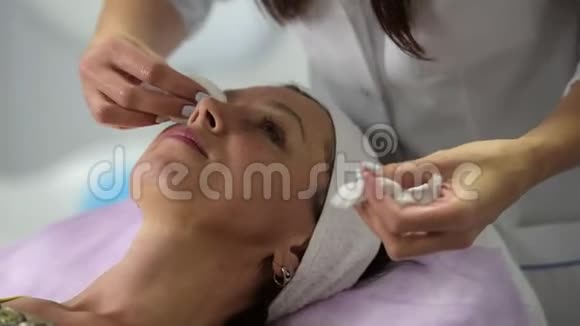 女孩美容师清理客户面部准备手续视频的预览图