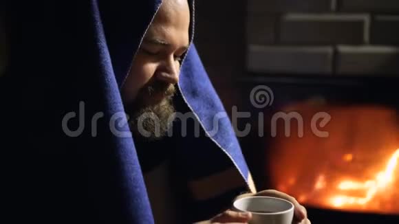 冬天晚上留着胡子的人在壁炉旁喝热茶视频的预览图