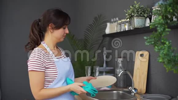 女人在厨房用毛巾擦盘子视频的预览图