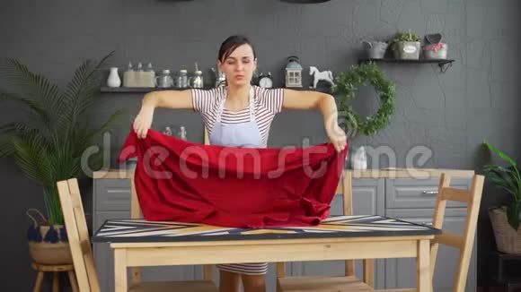 年轻女子在桌上铺桌布视频的预览图