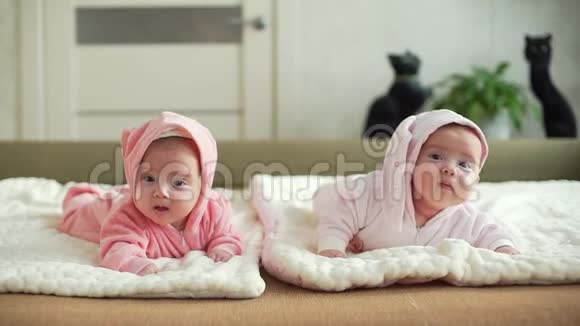 可爱的双胞胎姐妹婴儿躺在毯子上视频的预览图